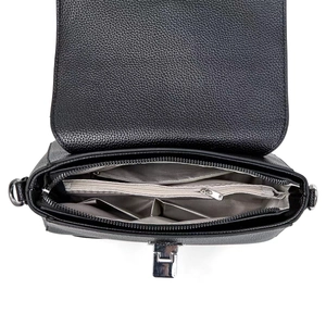 Macro detail of litchi grain leather texture and internal pockets of the black shoulder bag