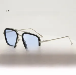 Detalle de gafas de sol aviador cuadradas con lentes azul claro y montura negro-plata