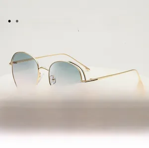 Detail of gradient blue-to-pink lenses and gold hollow metal frame on sunglasses