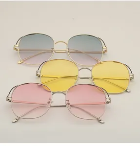 Flat lay of metal hollow sunglasses set in gradient blue, yellow, and pink lenses