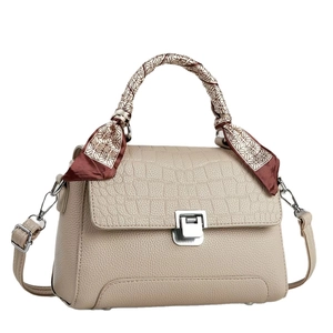 Chic beige crossbody bag with croc-embossed flap and silk scarf handle detail