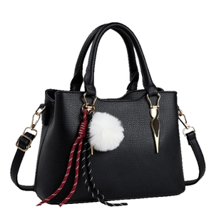 Black lychee pattern shoulder bag with faux fur pompom and golden hardware detail