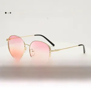 Detail of round gold metal frame sunglasses featuring pink-orange gradient lenses