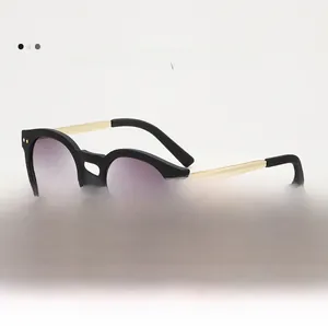 Detail view of oval vintage sunglasses with gold metal temples and UV400 gradient lenses