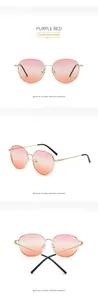 Detail view of oversized metal sunglasses featuring purple red gradient lenses and gold temples