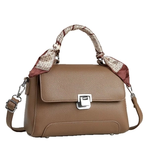 Brown litchi leather handbag with silk scarf handle and silver metal clasp on white background
