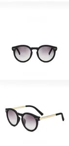 Detail of retro oval sunglasses with sand black frames and golden metal temples