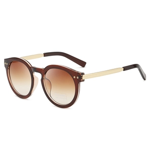 Retro oval sunglasses with translucent brown frames and golden metal temples on white background