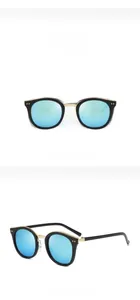 Dettaglio di occhiali da sole vintage rotondi con montatura nera e lenti blu specchiate