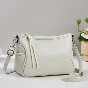 Détail du sac en cuir grainé blanc crème avec ferrures argentées et tirette de nœud tressé