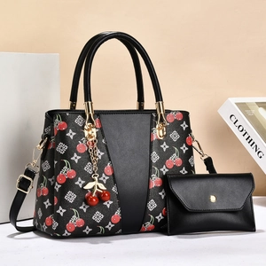Detail of black cherry print handbag with gold hardware and matching coin purse