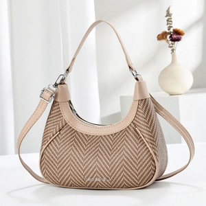 Macro shot of herringbone weave texture and beige leather trim on a hobo bag