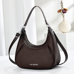 Close-up of brown woven crescent handbag showing leather handles and silver VB metal logo