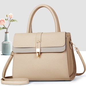Dettaglio borsa beige in pelle martellata con chiusura dorata e rifiniture grigie eleganti