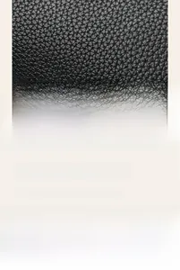 Detail of black lychee grain leather texture and silver metal hardware on handbag