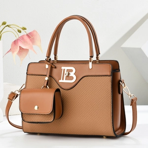 Bolso de mano marrón con logo B dorado y correa ajustable sobre fondo floral