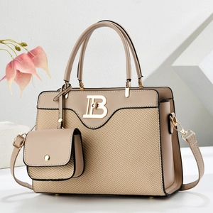 Detalle de bolso tote beige tejido con hebilla B dorada y correa de hombro