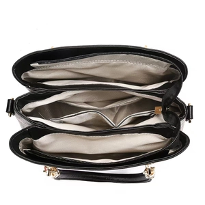 Internal view of a black leather handbag with herringbone lining and three compartments