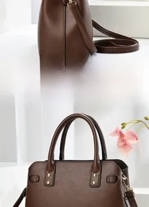 Detail view of dark brown pebbled leather handbag with gold rivets and detachable strap