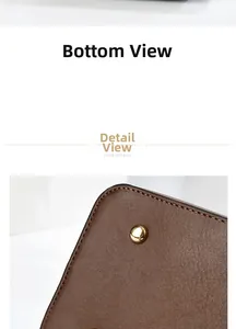 Close-up of brown leather bag bottom showing fine texture, stitching, and gold metal feet