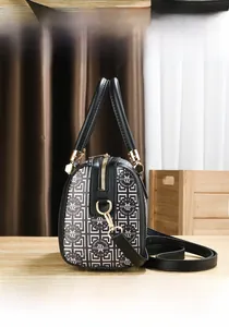 Detail der Boston Bag mit schwarz-weißem Geometrie-Print und goldenen Metallelementen