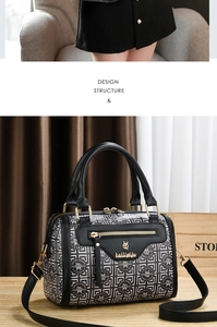 Detail of Boston bag with black and white geometric print and golden metal hardware