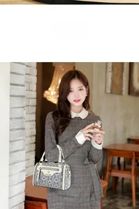 Chic Boston bag with black and white geometric pattern and elegant white leather handle