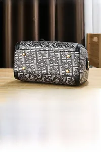 Detail shot of the Boston bag bottom featuring four protective gold metal feet and patterns