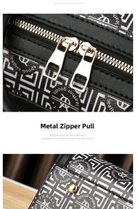 Detailed view of black leather handbag with golden double zippers and geometric pattern