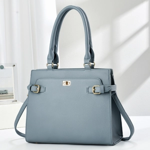 Detail of grey-blue leather handbag with golden metal twist lock and textured finish