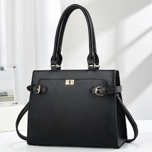 Close-up of black pebble leather tote bag with golden twist lock and textured finish
