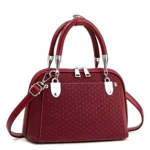 Fashionable dark red shell-shaped handbag with woven pattern and silver hardware on white background