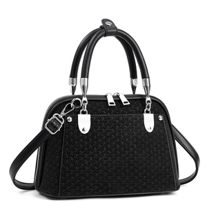 Detail of woven texture and smooth leather panels on black tote bag with silver zippers