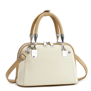 Detailed view of beige and khaki shell bag with silver hardware and smooth texture