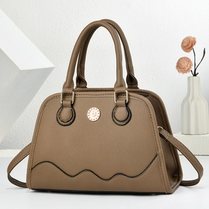 Brown lychee leather handbag with wave stitching and metal logo on a minimalist background