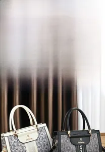Detail of soft leather handbags in black and cream featuring geometric color-block designs