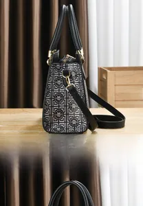 Detail of checkered shoulder bag with gold zipper and detachable strap on wooden table
