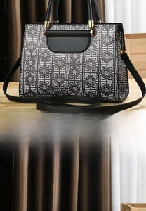Rear view of geometric patterned leather handbag with adjustable shoulder strap and gold hardware