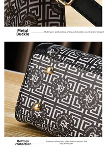 Detail of golden snap hooks and protective metal feet on a geometric leather handbag