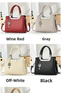 Detail view of four textured leather handbags in wine red, grey, beige, and black colors