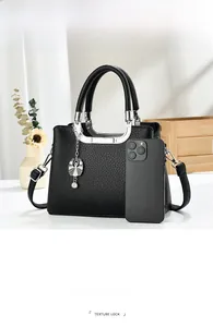 Detailed view of black litchi pattern handbag with silver hardware and multiple compartments