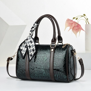 Sac de voyage vert foncé avec motif feuille gaufré, poignées brunes et foulard en soie