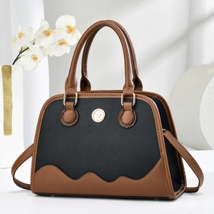 Detail of elegant two-tone leather handbag with gold metal buckle and wave pattern