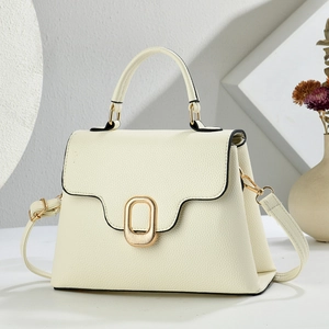 Minimalist beige pebble leather handbag with gold metal clasp on a textured white background
