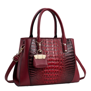 Deep red crocodile embossed handbag with gold hardware and adjustable crossbody strap