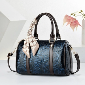 Sac Boston bleu gaufré avec poignées brunes et foulard pied-de-poule sur blanc