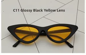 Detail view of cat eye sunglasses showing glossy black frame and transparent yellow lenses
