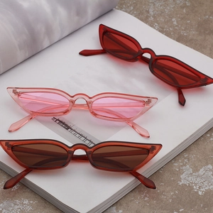 Detailed view of cat eye sunglasses in red, pink, and brown on a magazine