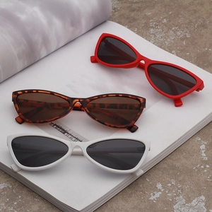 Close-up of cat-eye sunglasses in red, white, and leopard print on a magazine