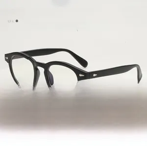 Detail view of round black frame glasses with silver diamond studs on a pedestal